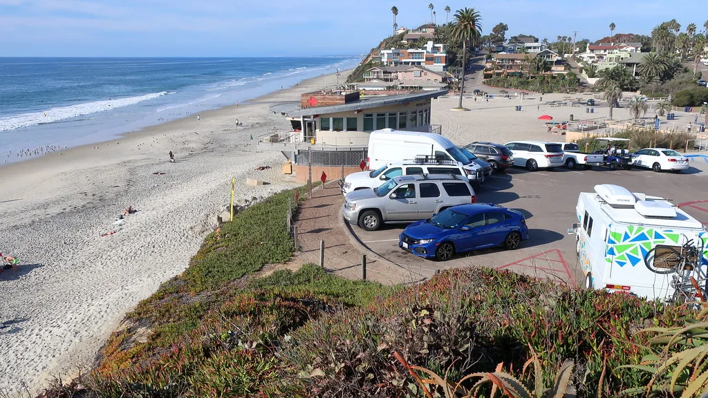 Moonlight Beach from the bluff: the lifeguard building, the free parking lot and the sand